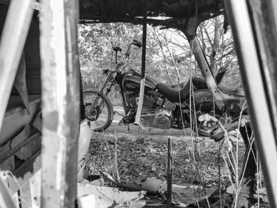 Black chopper seen through the ribs of a rusted frame