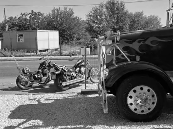 Two choppers parked next to a flame-painted truck